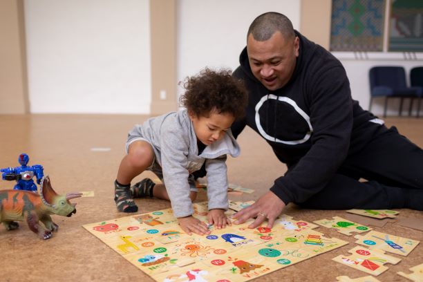 Father doing a puzzle with small child