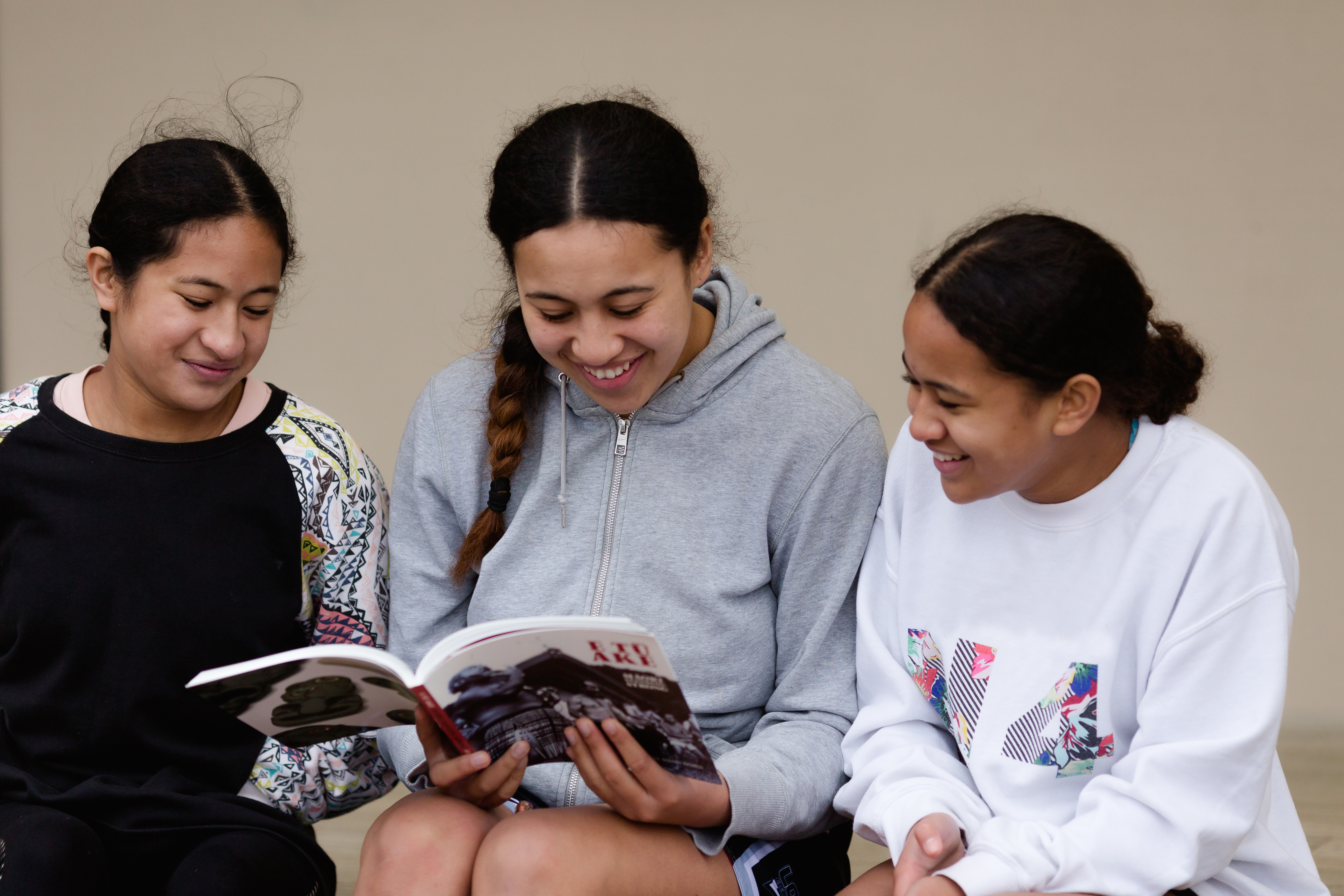Three teen girls reading