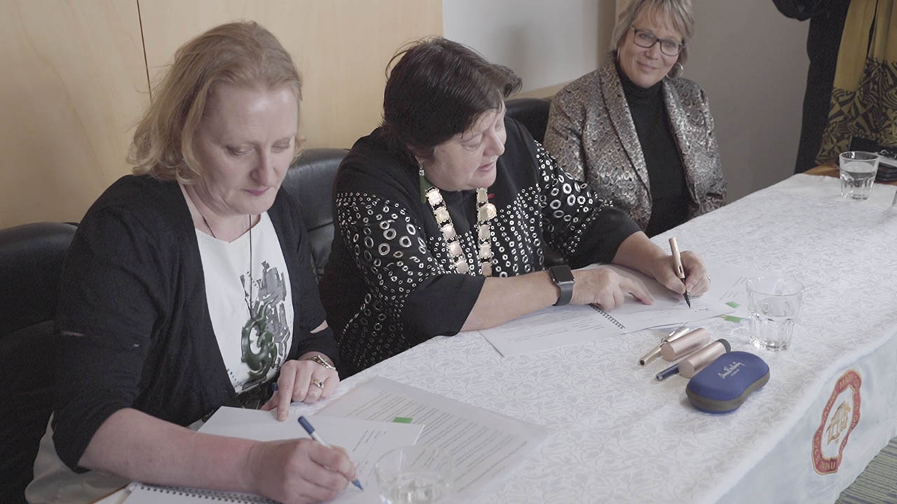 Three officials signing the partnership