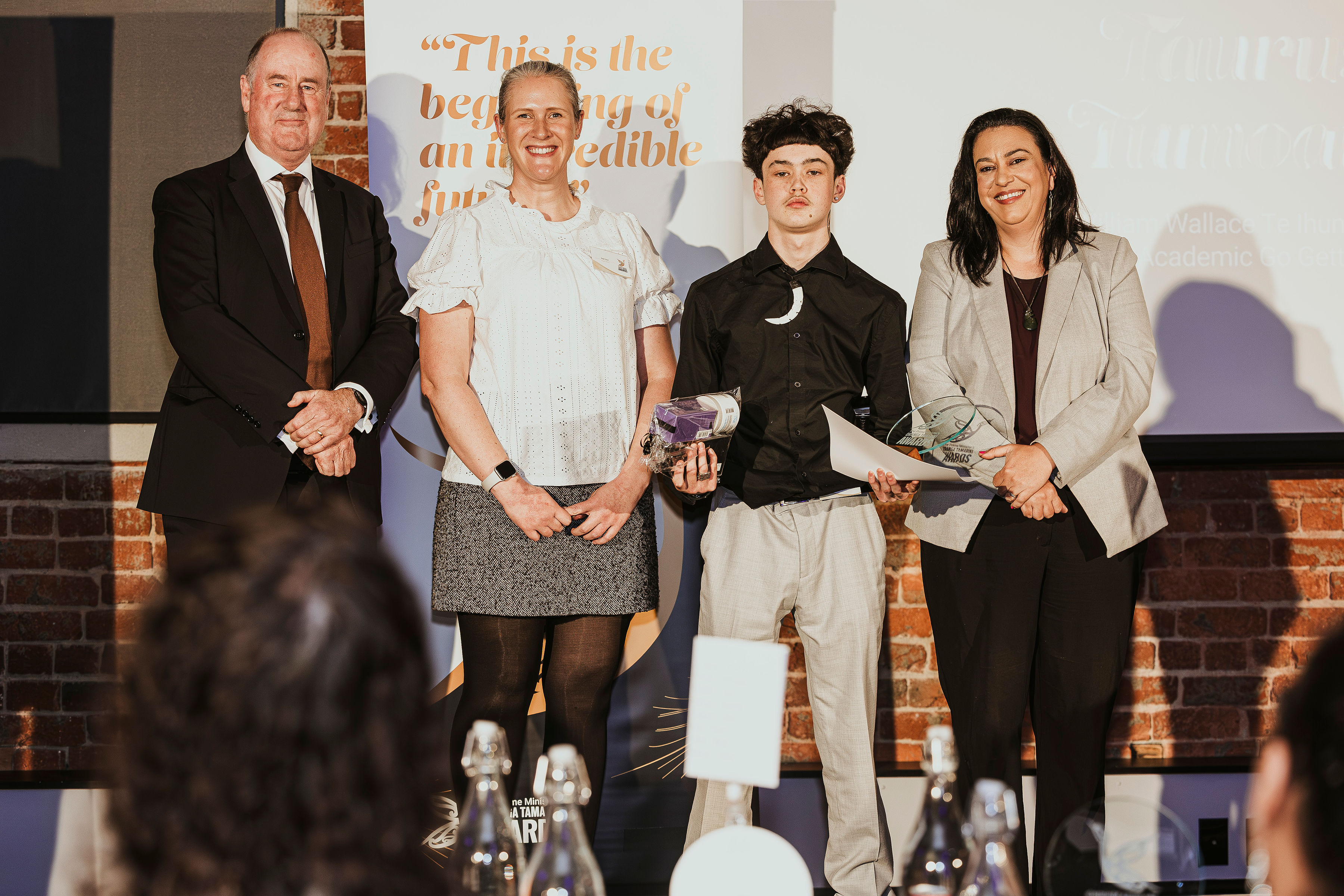 Taurus receiving his award on stage with Andrew Steph and Minister