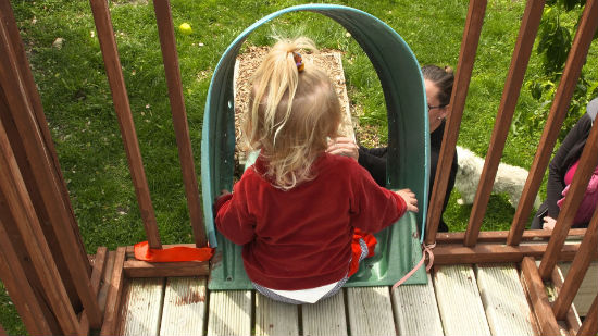 A little girl going down a slide