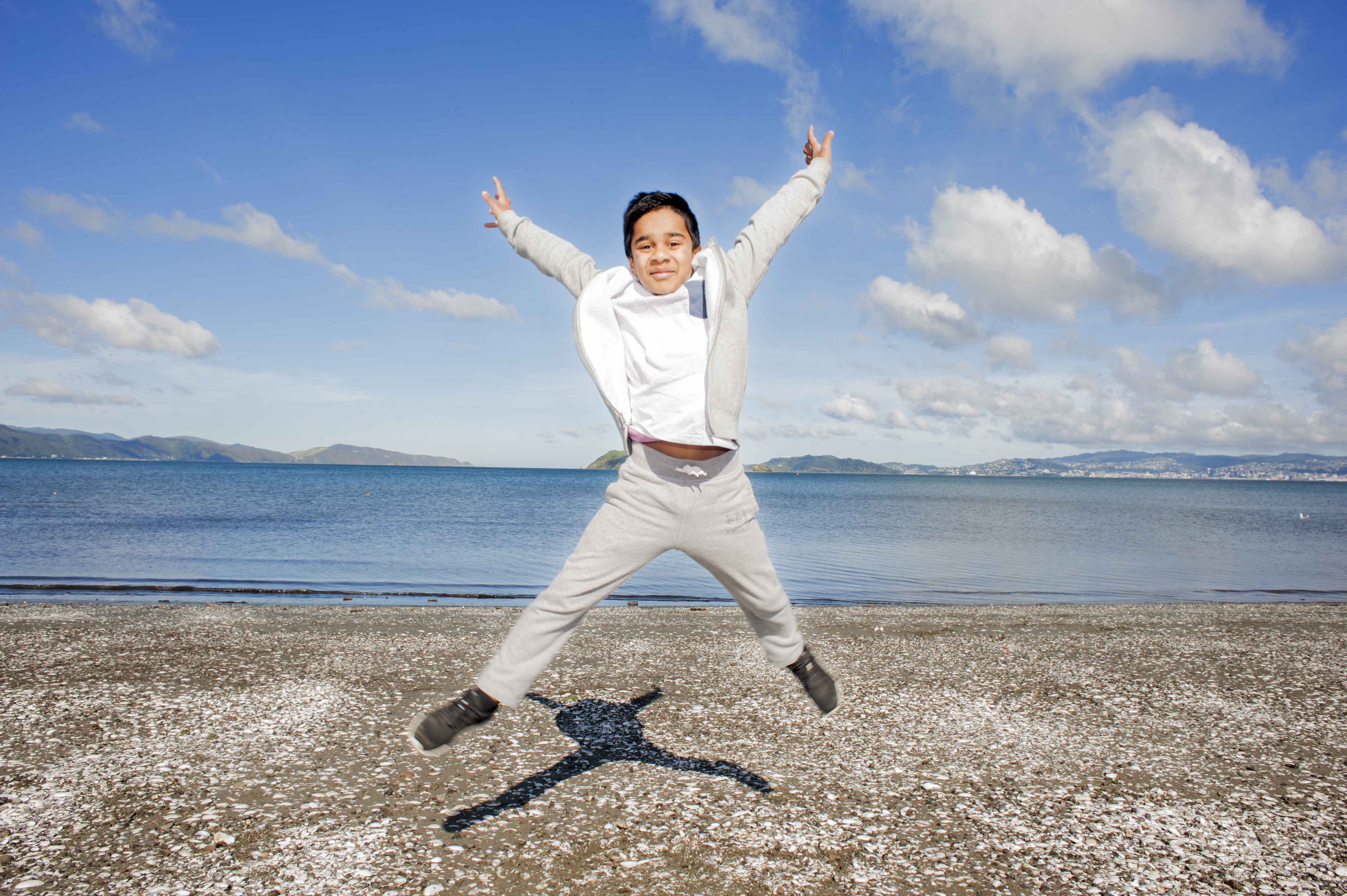 Boy star jumping on beach